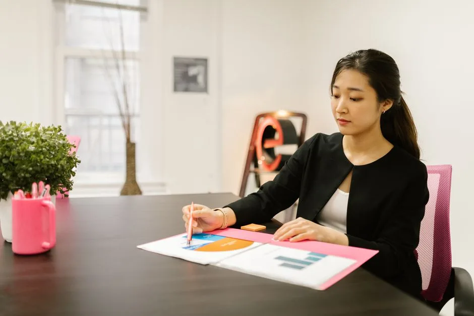 Dirigeante de PME relisant un prévisionnel à son bureau